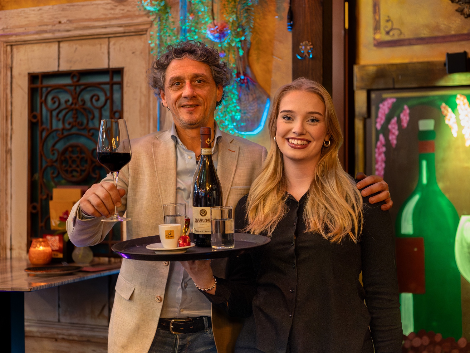 Mano en Layla met een dienblad wijn en koffie